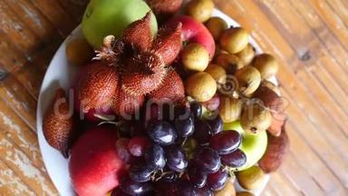 顶部的美味和安排热带水果在碗上的木制桌子。 慢动作。 1920x1080